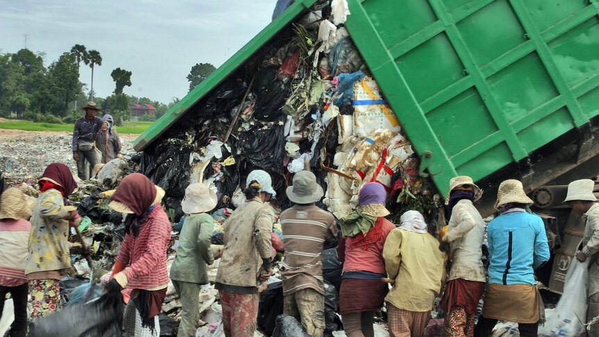 People scrounge for food at a Cambodian rubbish dump