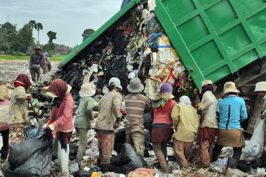 People scrounge for food at a Cambodian rubbish dump