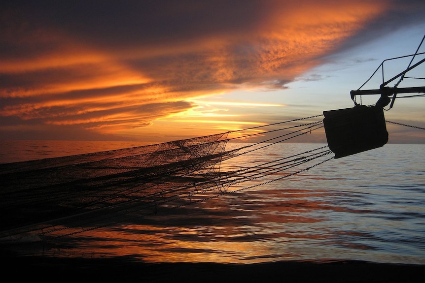 Sun sets over a trawler boom in Gulf of Carpentaria's northern prawn fishery