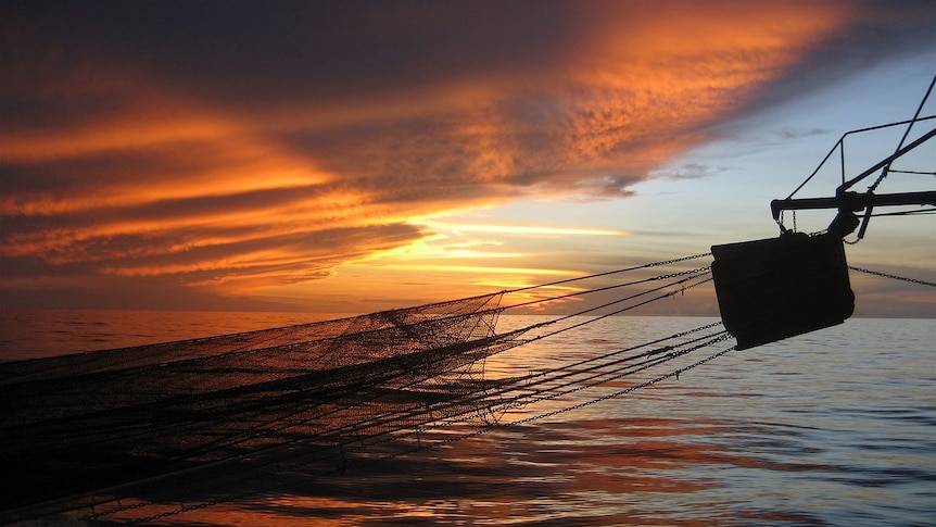 Sun sets over a trawler boom in Gulf of Carpentaria's northern prawn fishery