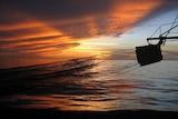 Sun sets over a trawler boom in Gulf of Carpentaria's northern prawn fishery