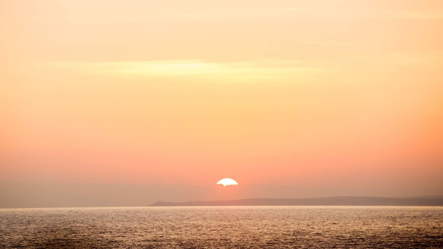 The sun sets over the mainland, as seen from Gabo Island.