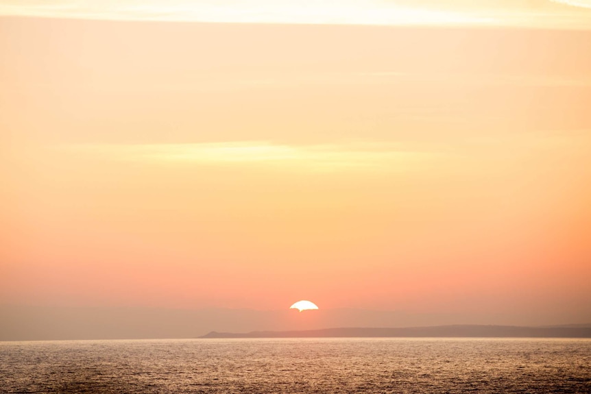 The sun sets over the mainland, as seen from Gabo Island.