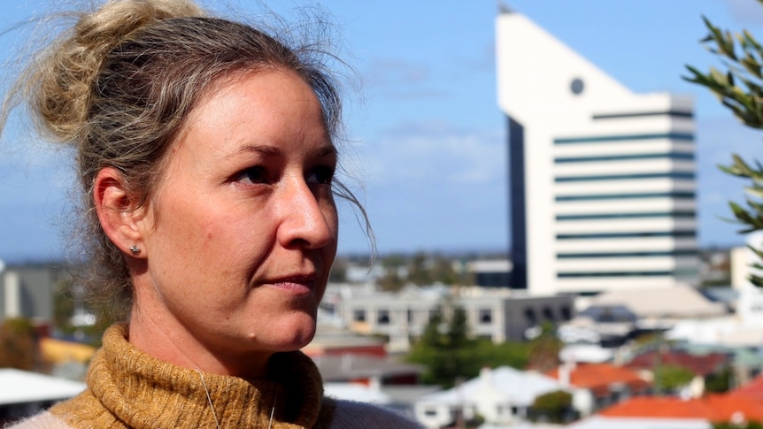 A woman with her hair in a bun, standing in front of the Bunbury Tower