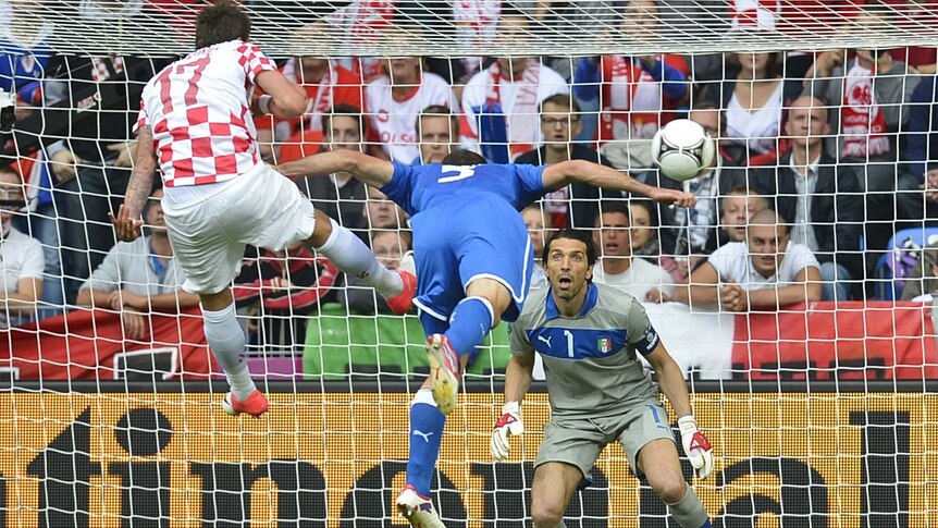 Giorgio Chiellini (centre) heads the ball