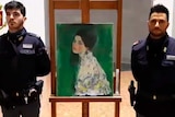 Two police officers stand either side of the painting