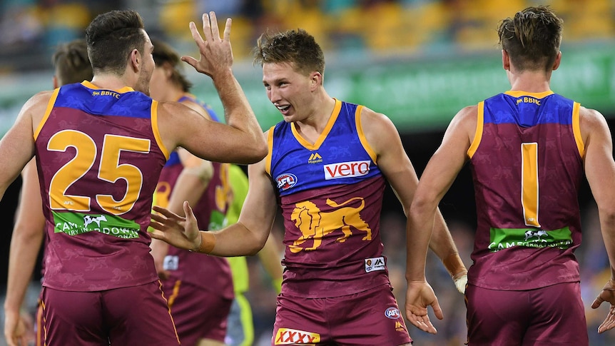 Alex Witherden of the Lions (C) celebrates his first goal against Carlton at the Gabba.