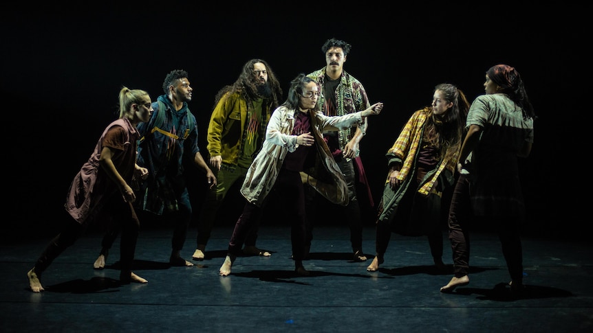 Seven dancers pose on stage for the performance Silence