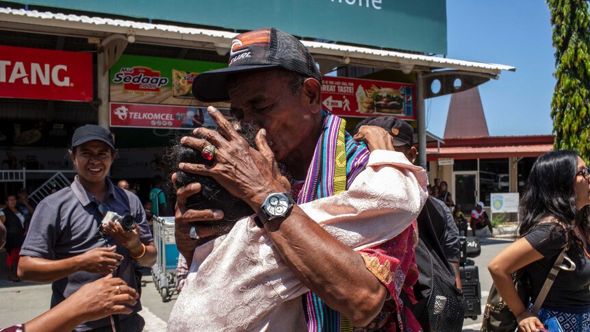 A man embraces his Timorese family in Dili.
