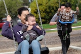 Family playing on swings.