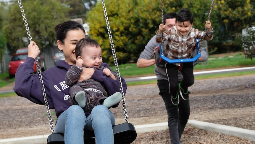 Family playing on swings.