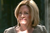 A head and shoulders shot of a smiling Lisa Scaffidi walking outdoors.