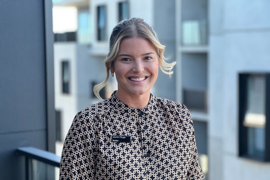 Real estate agent Jazmin Pfluger stands on the balcony of an apartment.