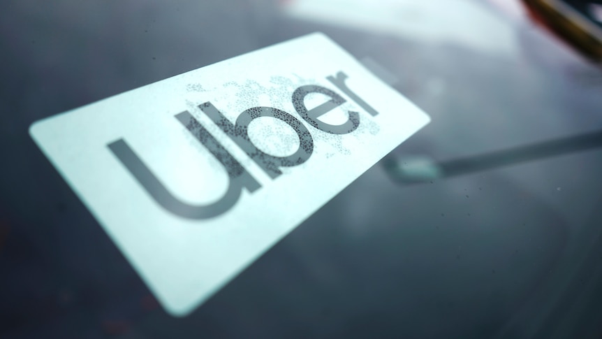 A close up of a sticker on car window, containing the word Uber.