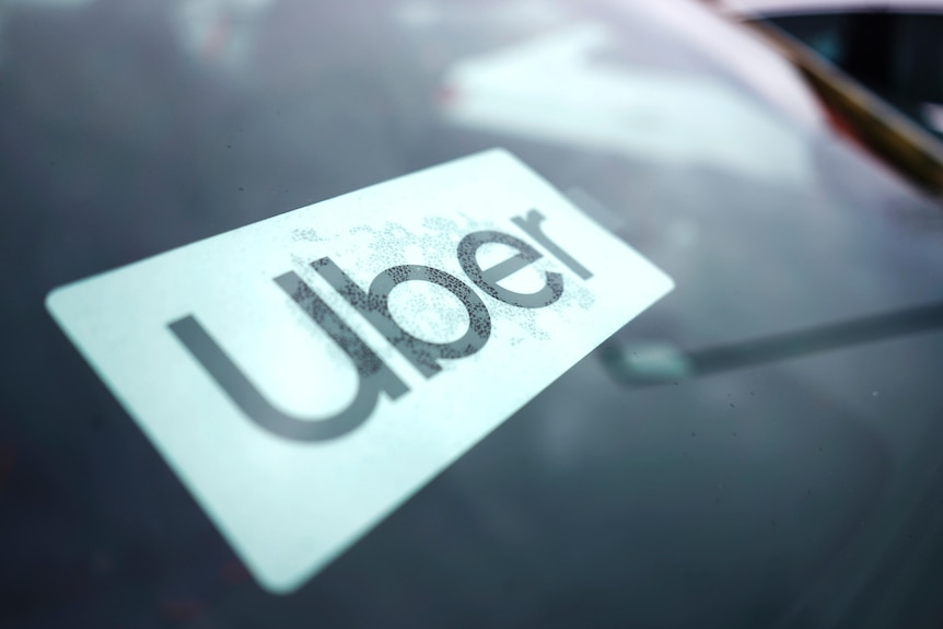 A close up of a sticker on car window, containing the word Uber.