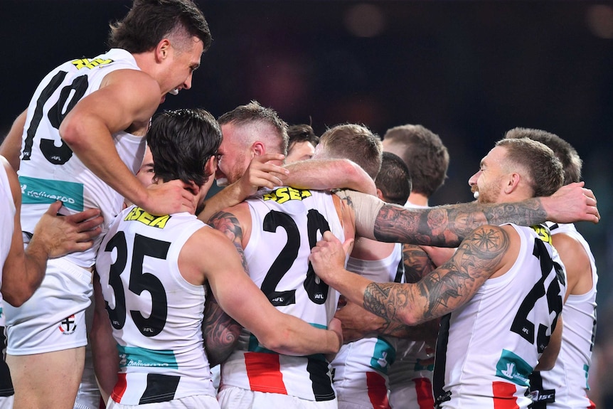 A large group of St Kilda players congregate in jovial celebration