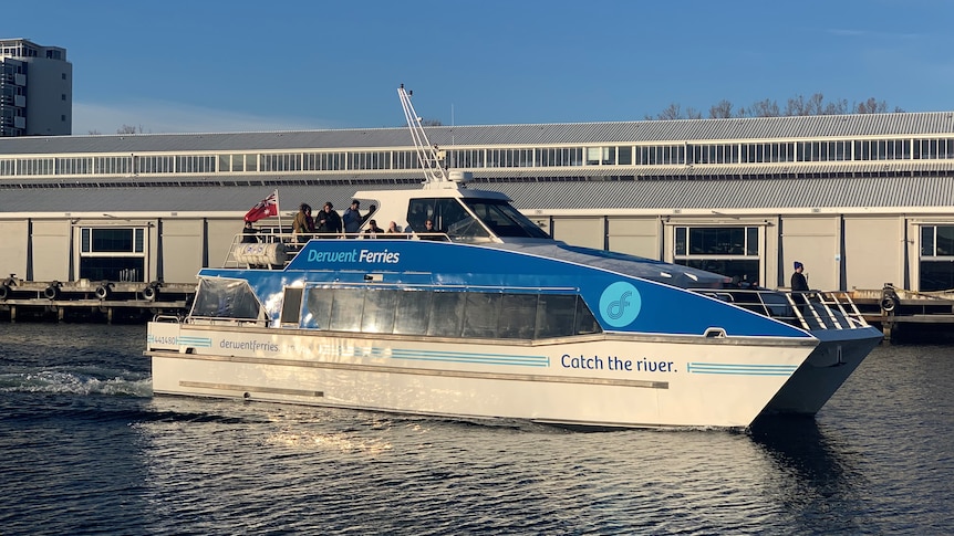 Ferry with passengers on board near a pier.