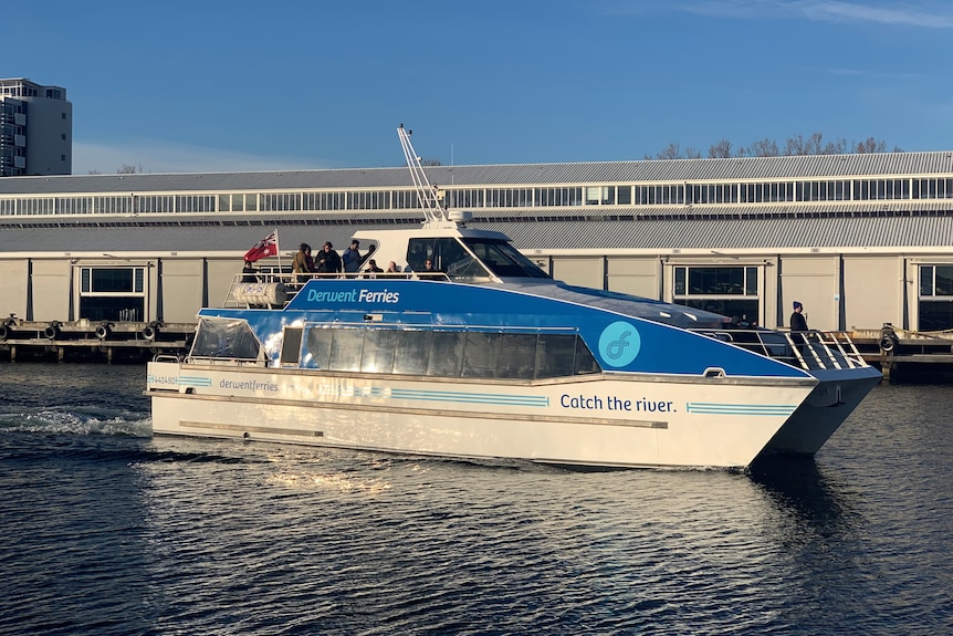 Ferry with passengers on board near a pier.