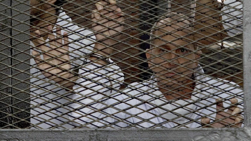 Australian journalist Peter Greste stands in a defendants cage inside a court in Cairo on March 5, 2014.