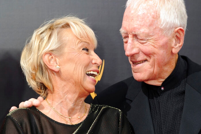 An elderly couple smile at each other