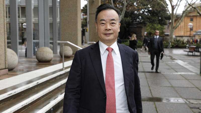 A man in a red tie walking down a street.