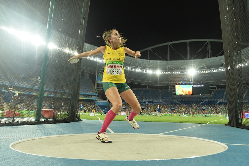 Rae Anderson in the motion of throwing the discus in the throwing circle.