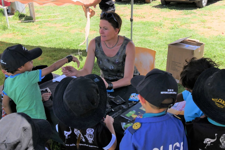 Tash Morton speaks to school children visiting her recycling stall at the Wilcannia careers fair