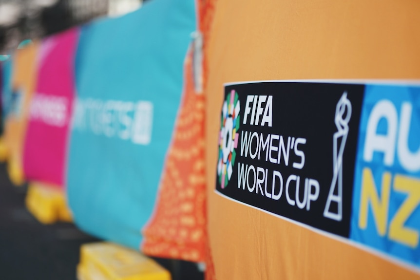 A close-up of a logo in black and white on an orange background, with the words 'FIFA Women's World Cup 2023'.
