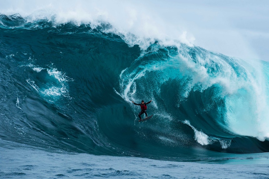 Large wave with surfer going down.