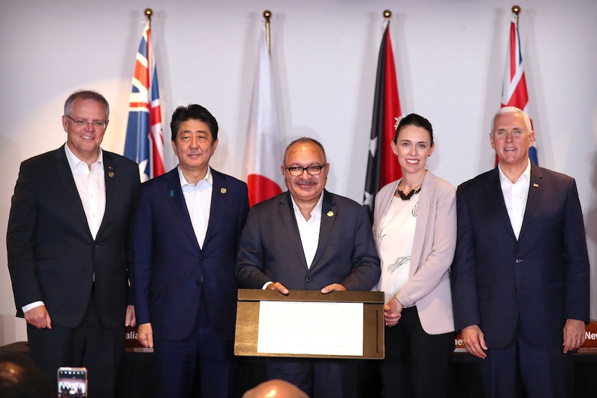 World leaders stand in front of their respective flags