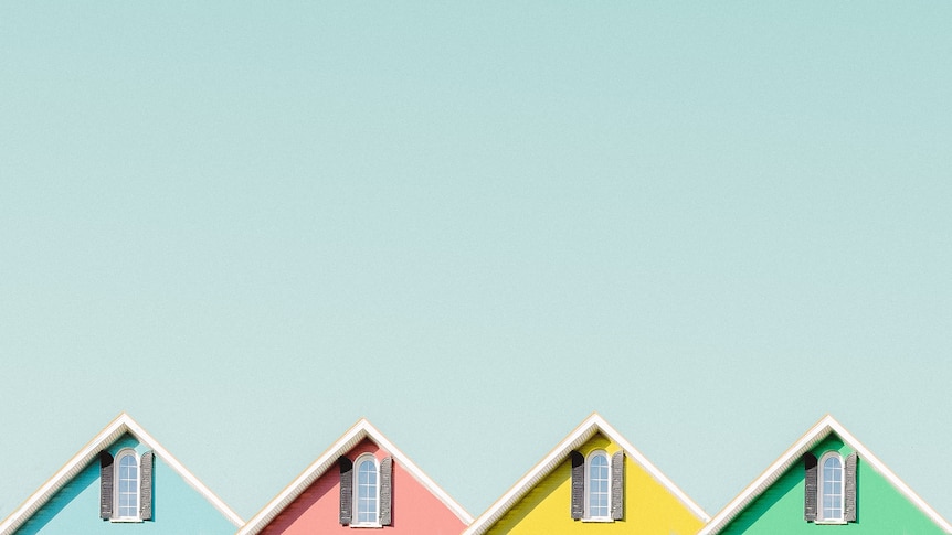 Cartoon of bright coloured houses against blue backdrop. 
