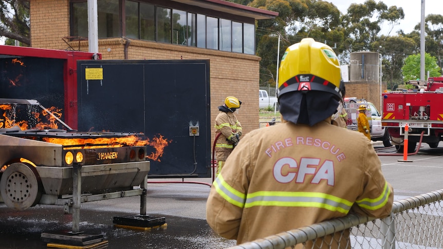 a man in a CFA jacket watches a fire rescue