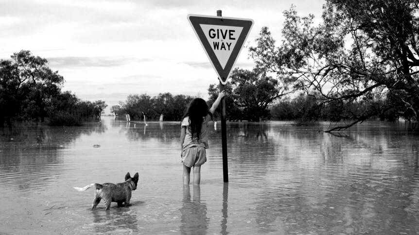 Isla McCarthy with her pup Muttly at the Bulloo River bridge in the April 2019 floods.
