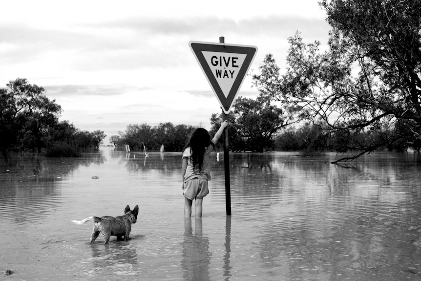 Isla McCarthy with her pup Muttly at the Bulloo River bridge in the April 2019 floods.