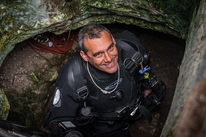 Diver Craig Challen smiles as he emerges from the entrance to Tank Cave.