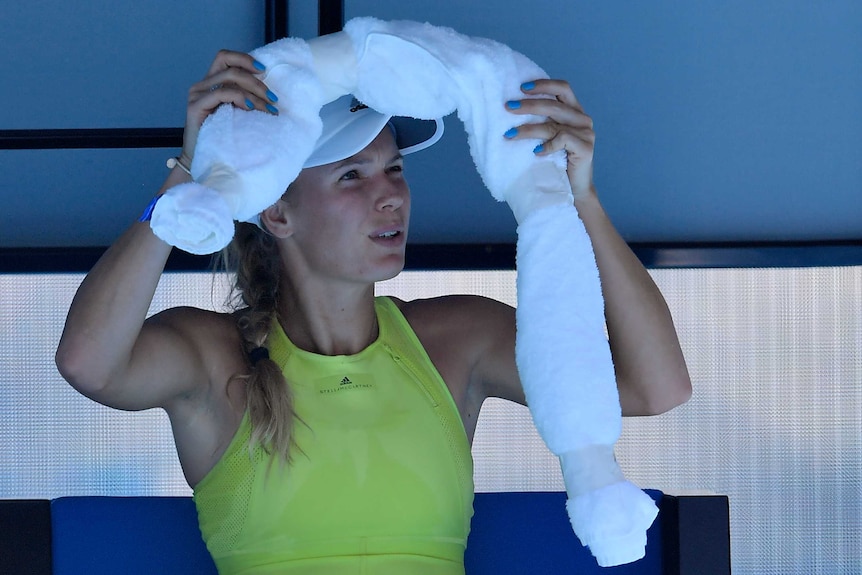 Caroline Wozniacki puts an ice towel around her neck while sitting down at a change of ends at the Australian Open.