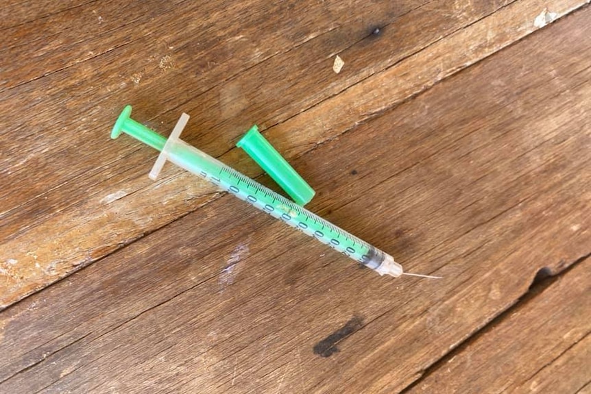 A green syringe on a table