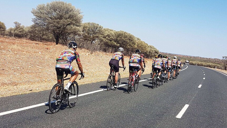 A group of cyclists on a bitumen country road.