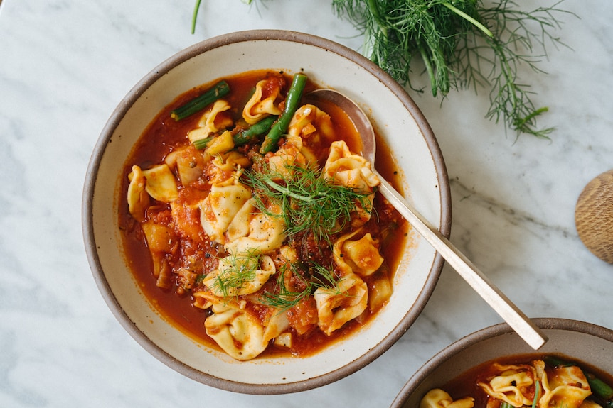 A bowl of tortellini soup