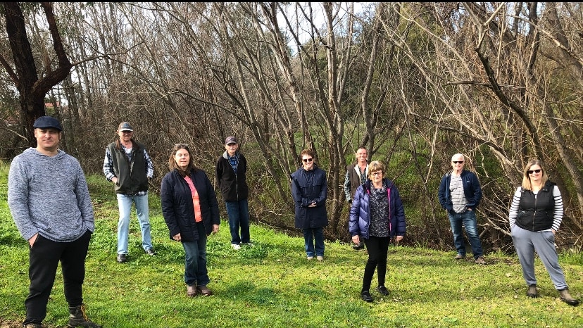 Residents standing alongside creek bed