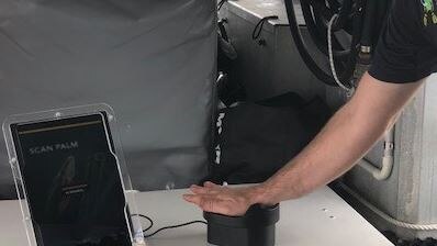 person scanning hand on palm scanner