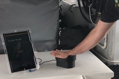 person scanning hand on palm scanner