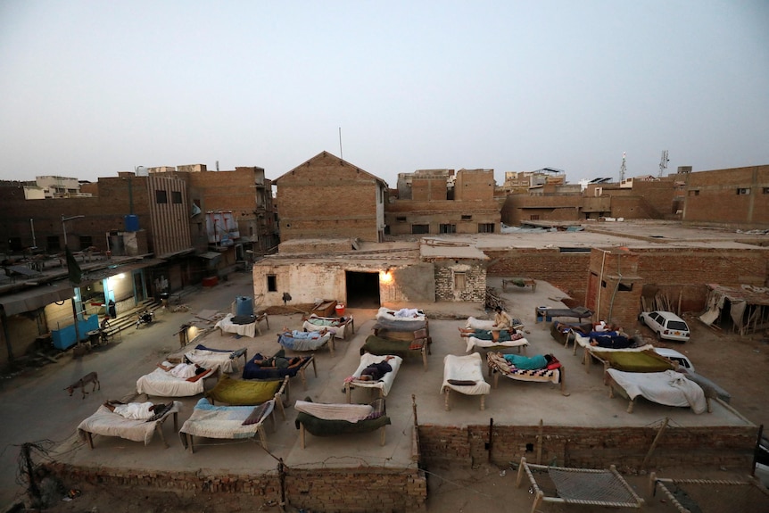 Men sleeping on a roof.