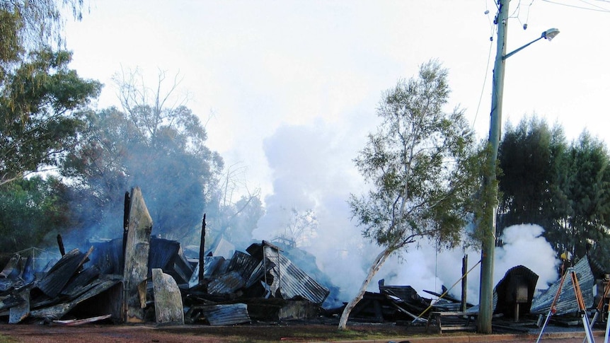 The Eulo General Store after a fire in 2011 with plumes of white smoke emitting from the wreckage