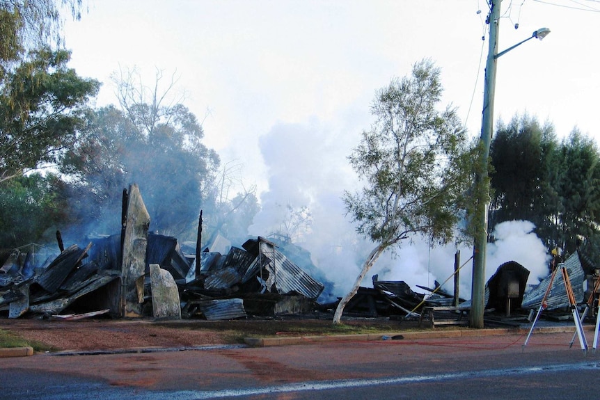 The Eulo General Store after a fire in 2011 with plumes of white smoke emitting from the wreckage