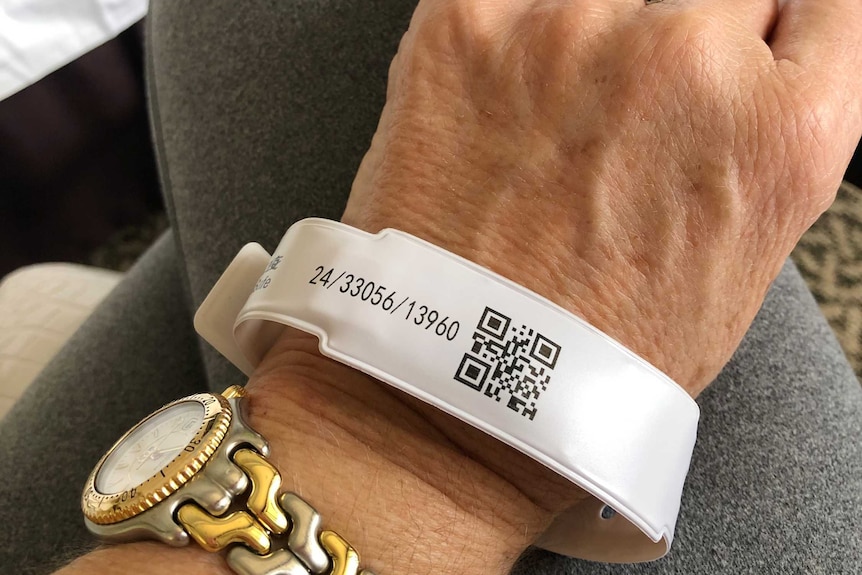 A wristband with a QR code sits on a woman's wrist.