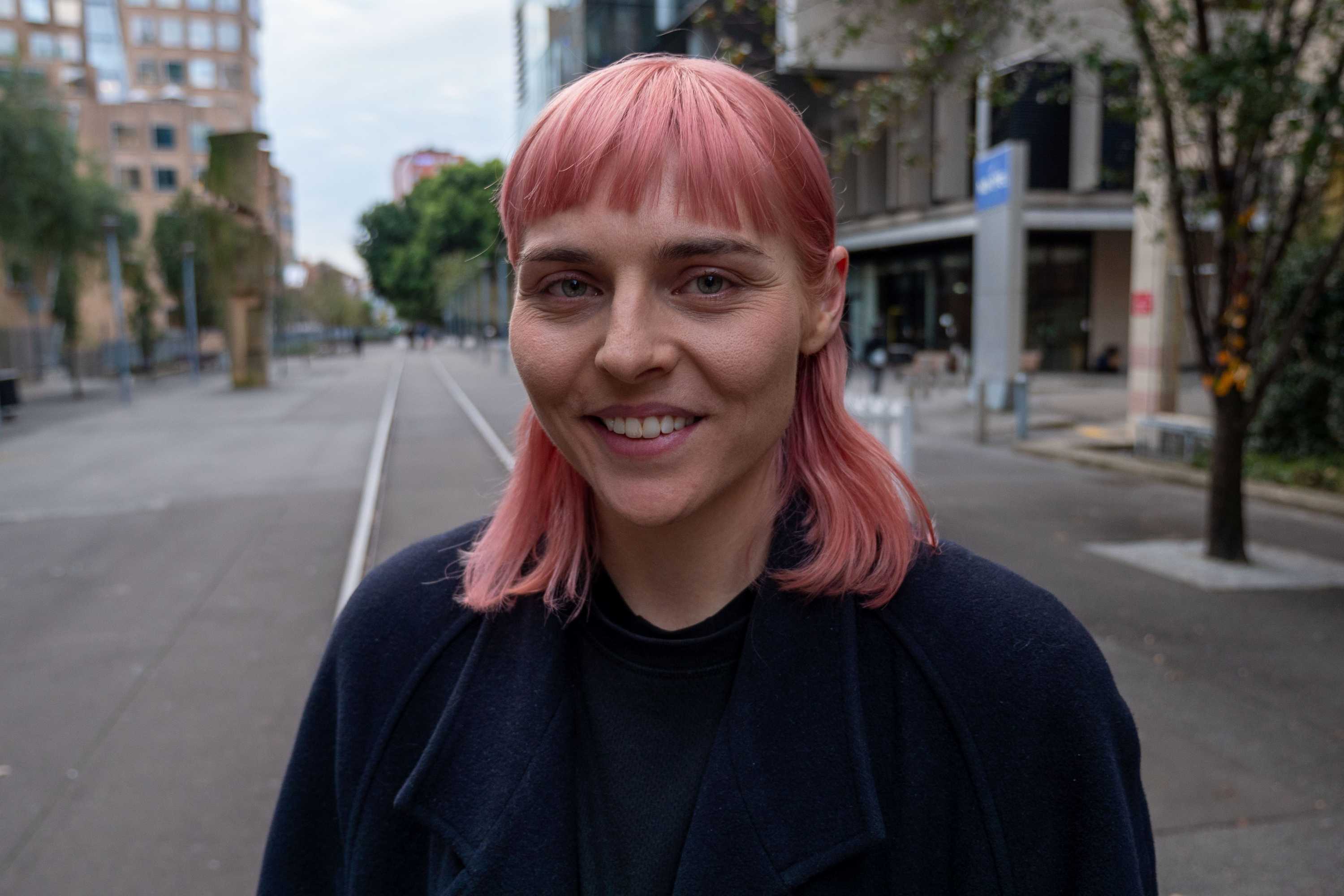 Angela Lavoipierre, standing in a city landscape.