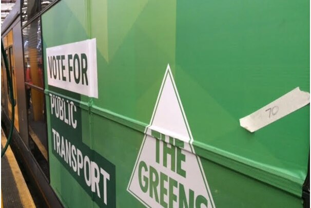The side of a Sydney train with a Greens advertisement.