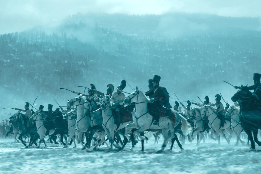 A snow swept battle scene featuring hundreds of soldiers on horseback charging with weapons in hand.