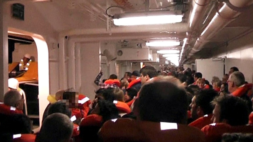 Passengers wearing life vests stand in the corridors of the Costa Concordia.